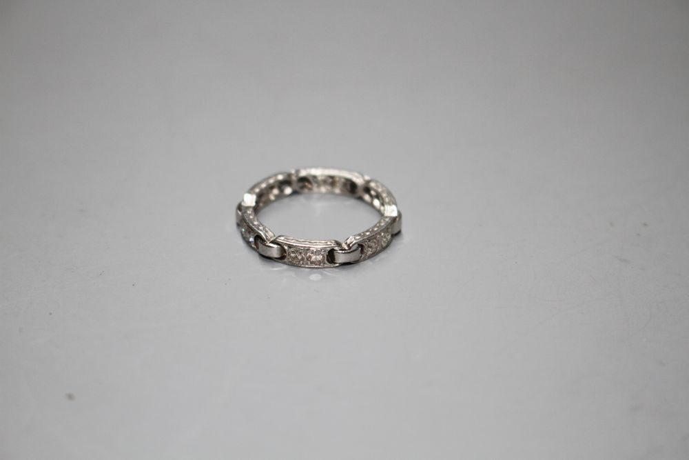 An unusual white metal (stamped Plat) and twelve stone diamond set eternity ring,